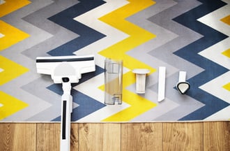 cleaning-supplies-arranged-on-colorful-rug-on-wood-web