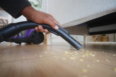 hand-using-vacuum-cleaner-to-clean-crumbs-web