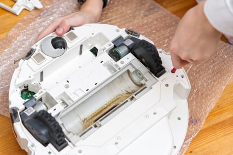 hands-disassembling-a-robot-vacuum-cleaner-for-mai-web