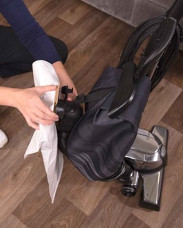 A woman installing a hepa filter into a Kirby vacuum
