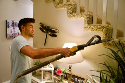 man-using-vacuum-cleaner-inside-house-web