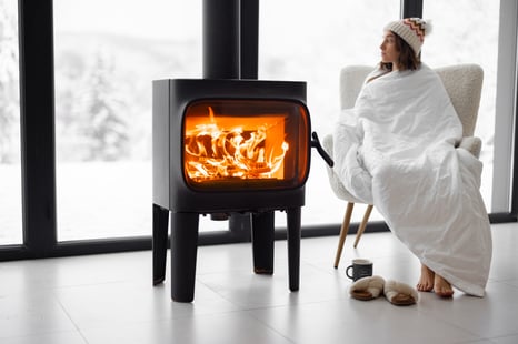 woman-at-home-with-burning-fireplace-during-winter-2022-01-19-04-31-16-utc